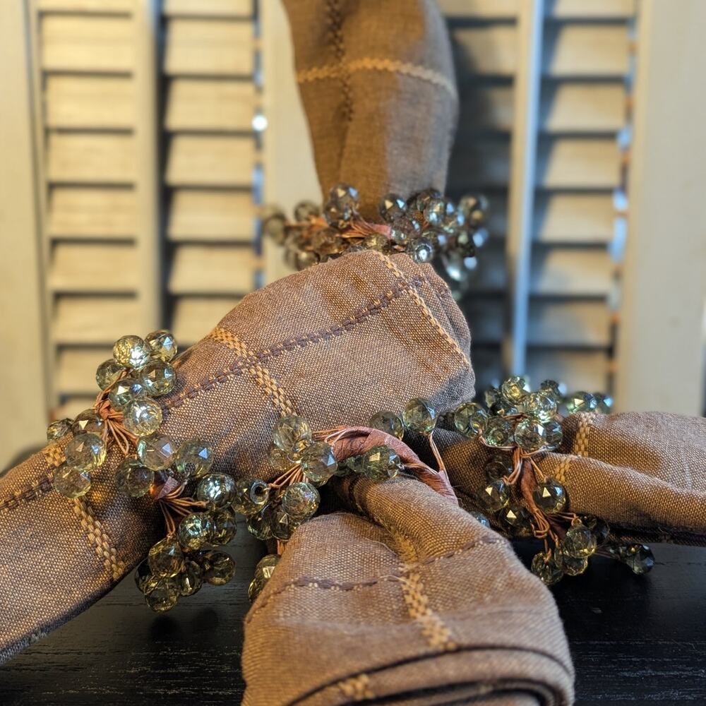Woven brown linen napkins with green beaded napkin rings